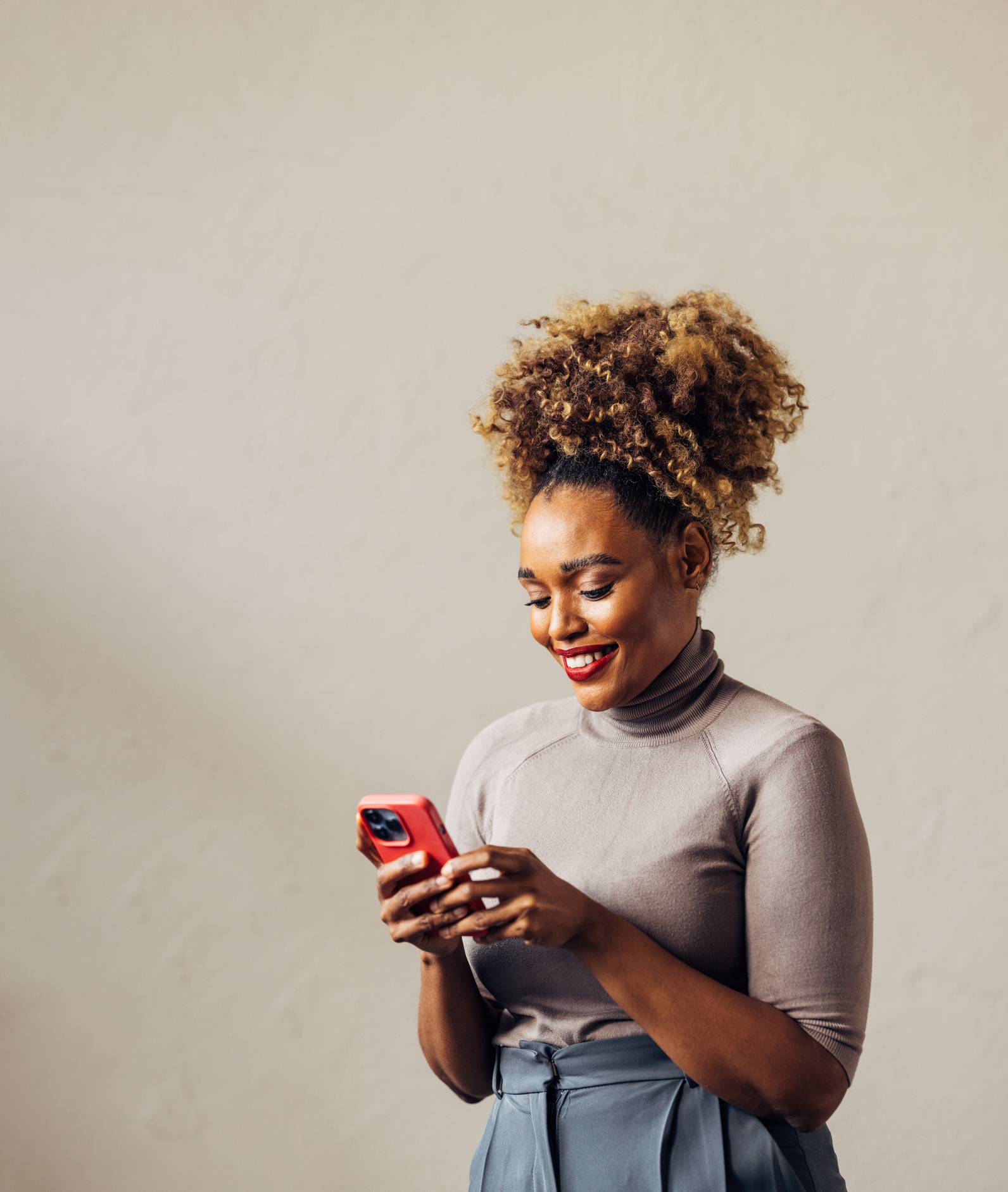 A woman smiles at a phone.