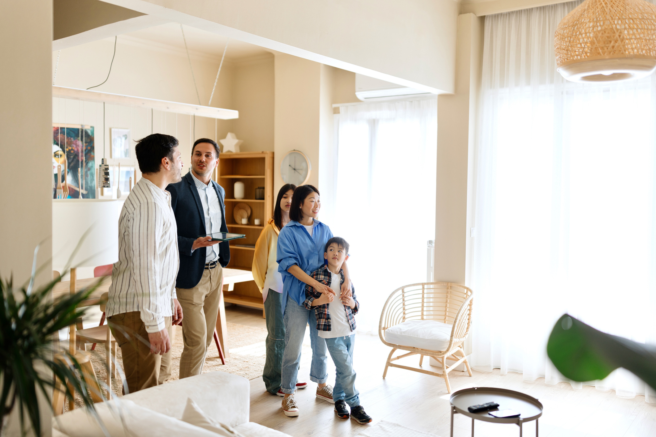 A family smiles while touring a house for sale.