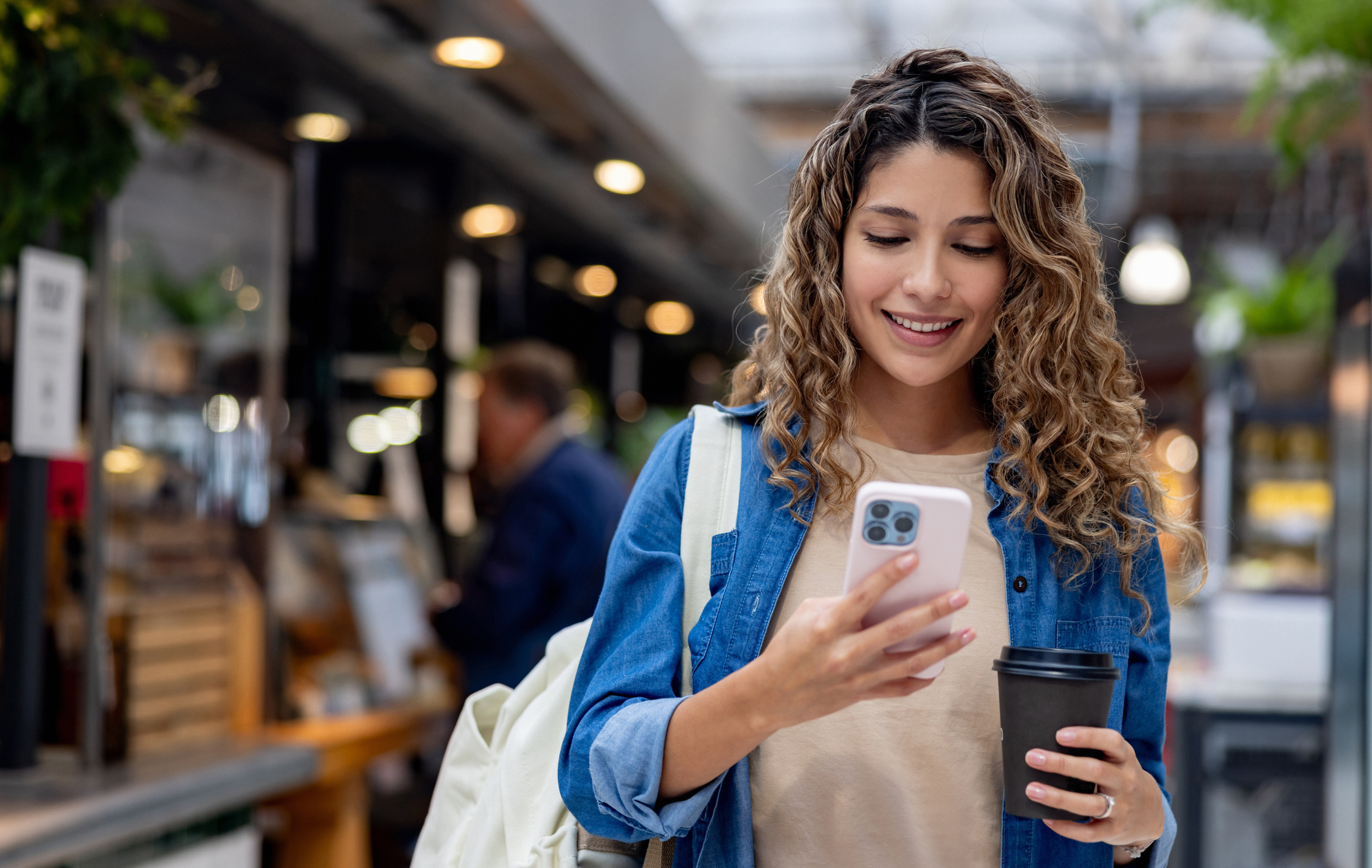 A woman smiles at a phone.