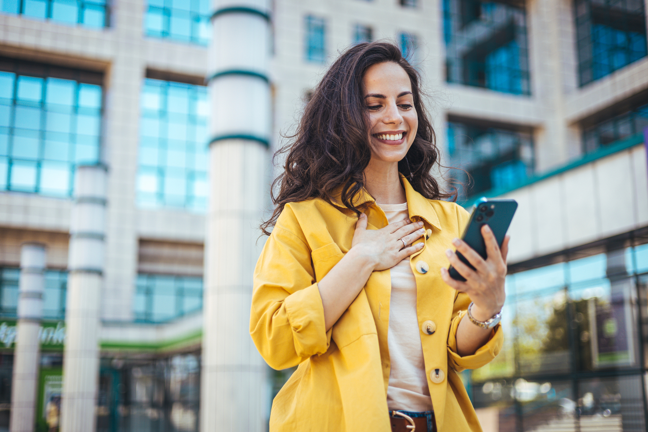 A woman smiling at a phone.