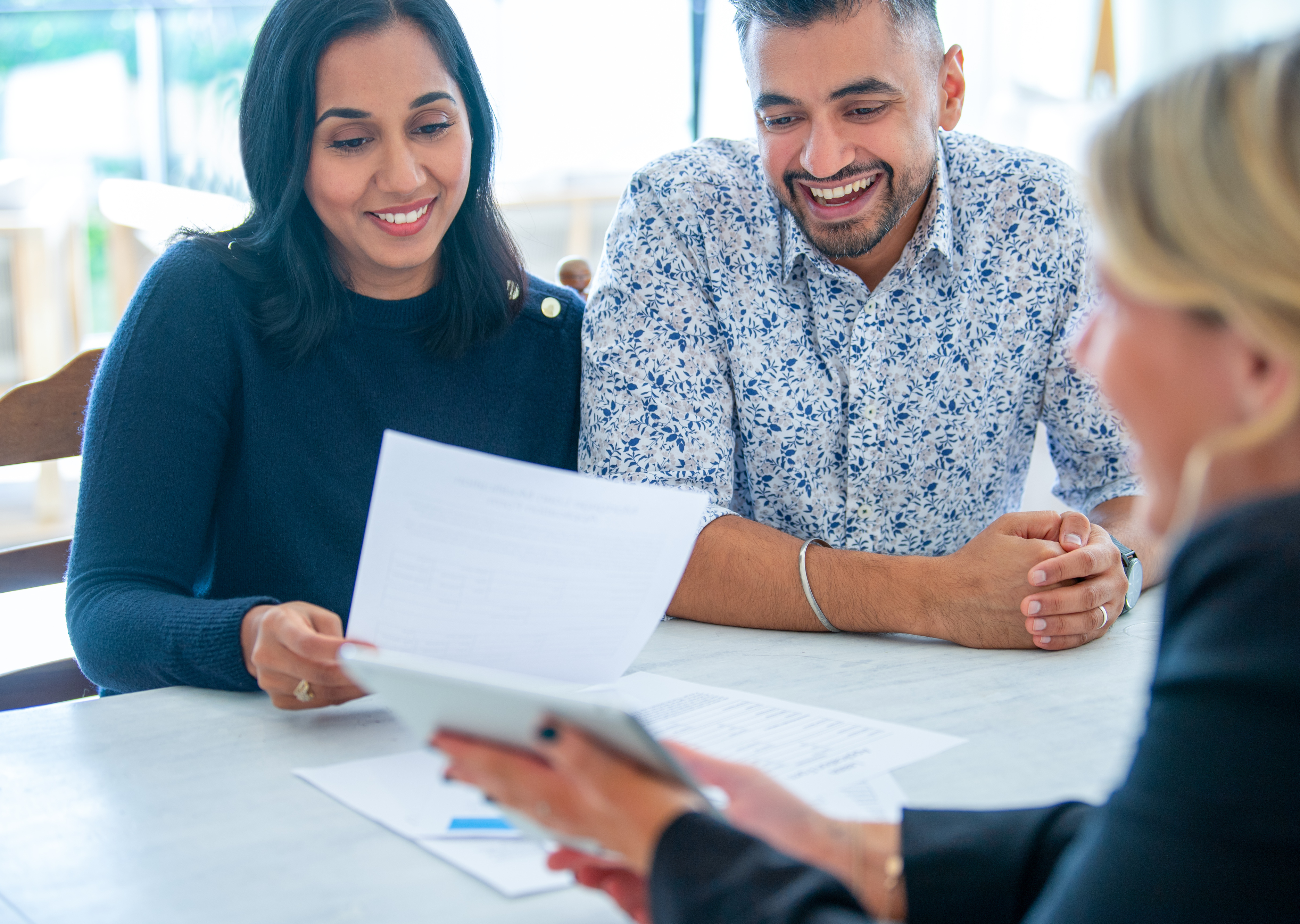 People smile while closing on a loan.