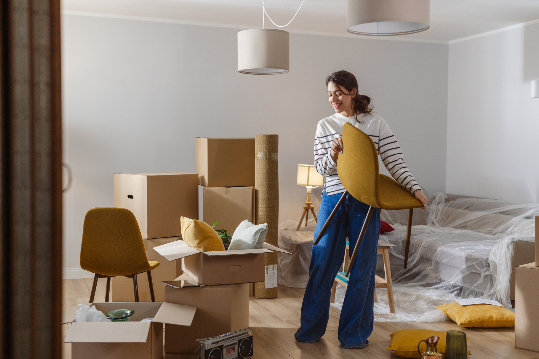 A woman moves a chair into a new house.