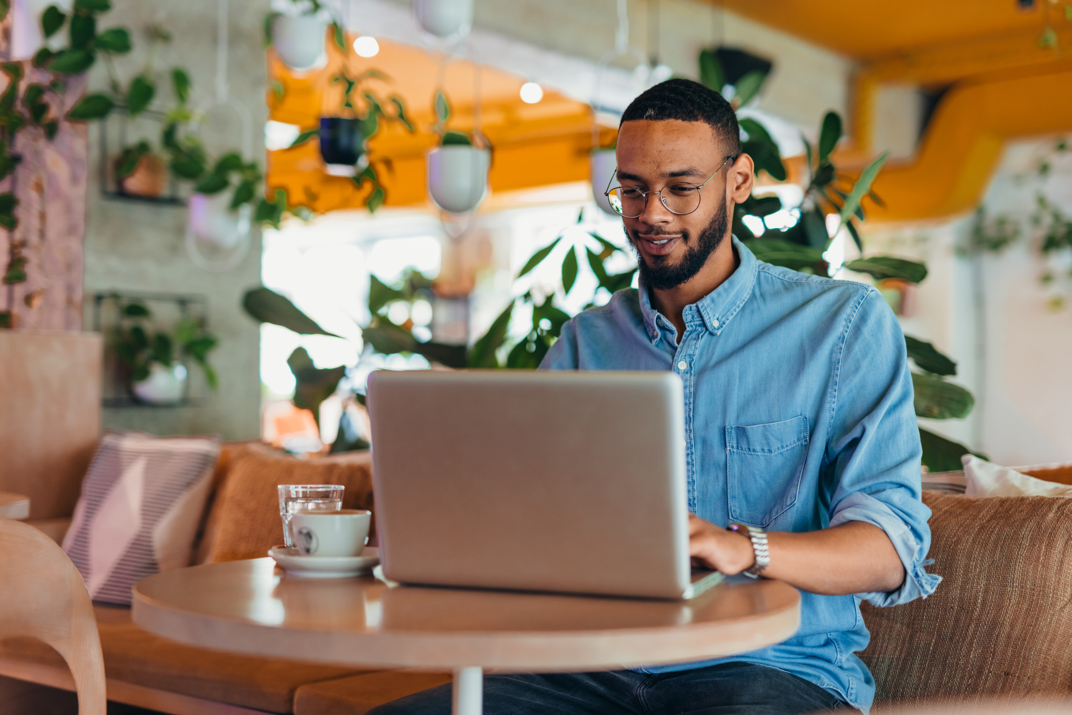 A man smiles while using a laptop.