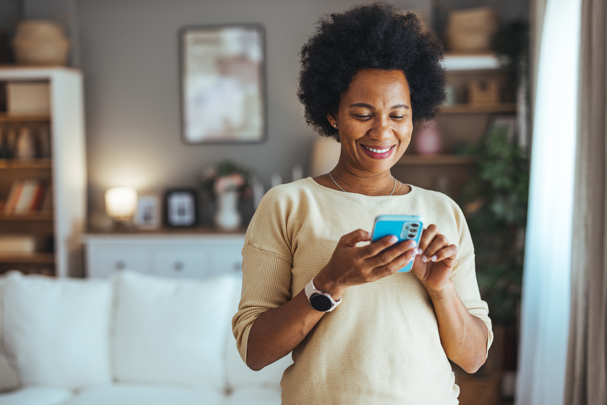 A woman smiling at a phone.