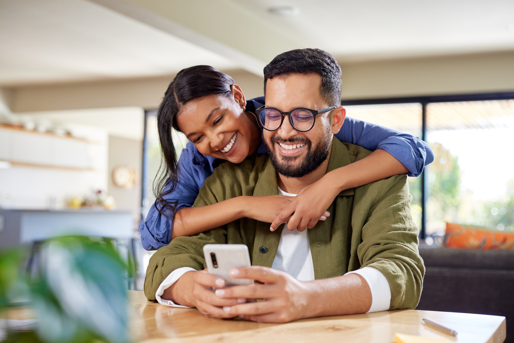 A man and a woman smiling at a phone