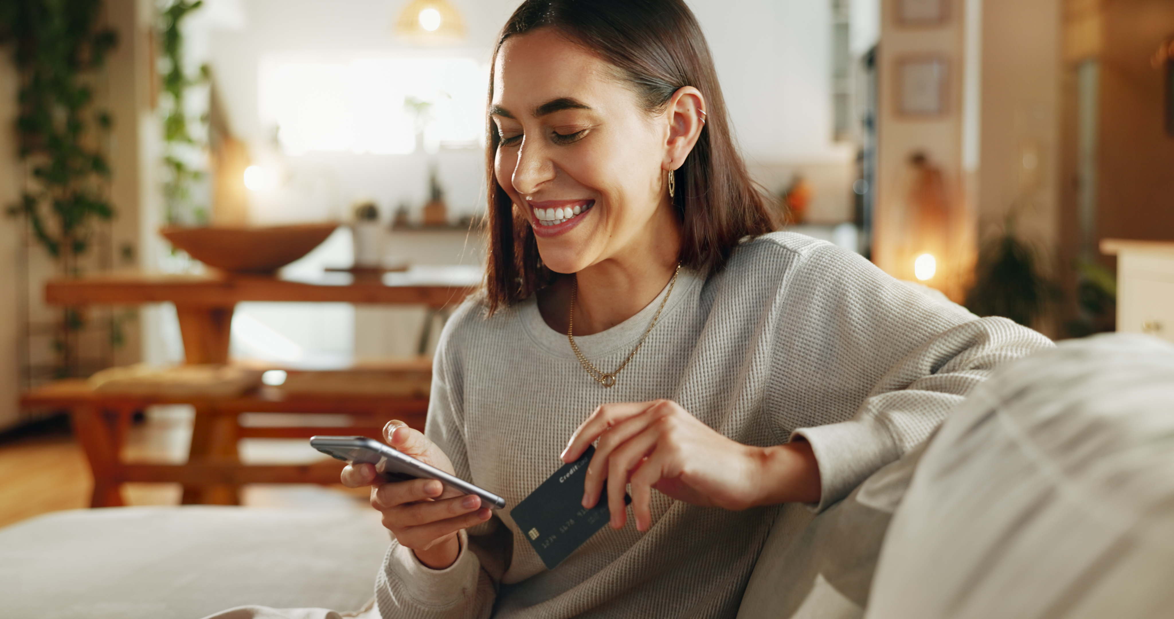 A woman smiles at a phone.