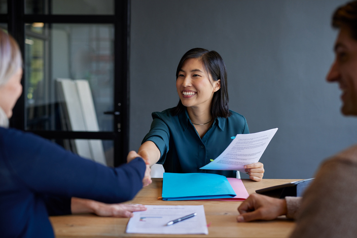 A woman smiles while discussing rate lock details with a loan officer.