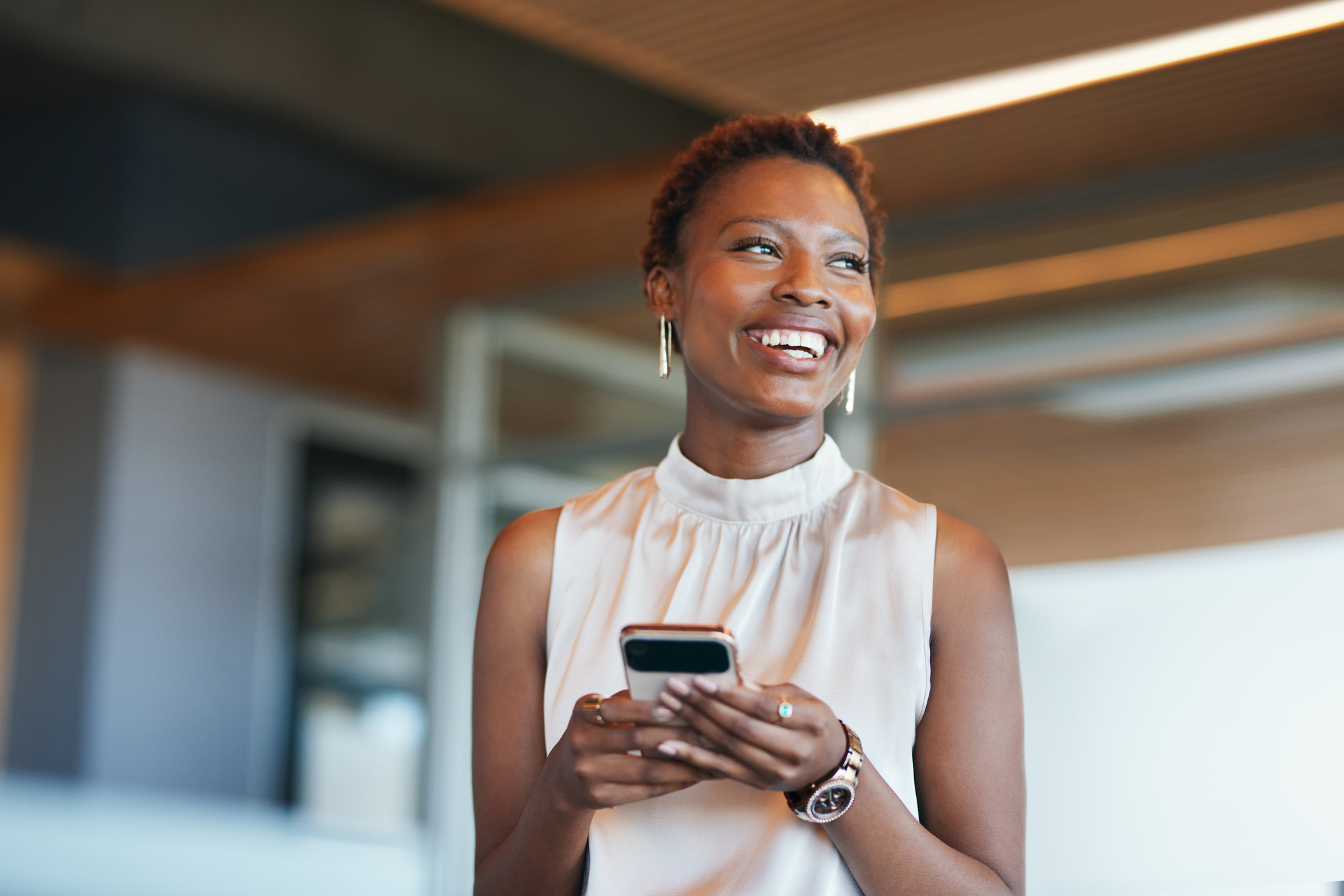 A woman smiling with a cell phone.