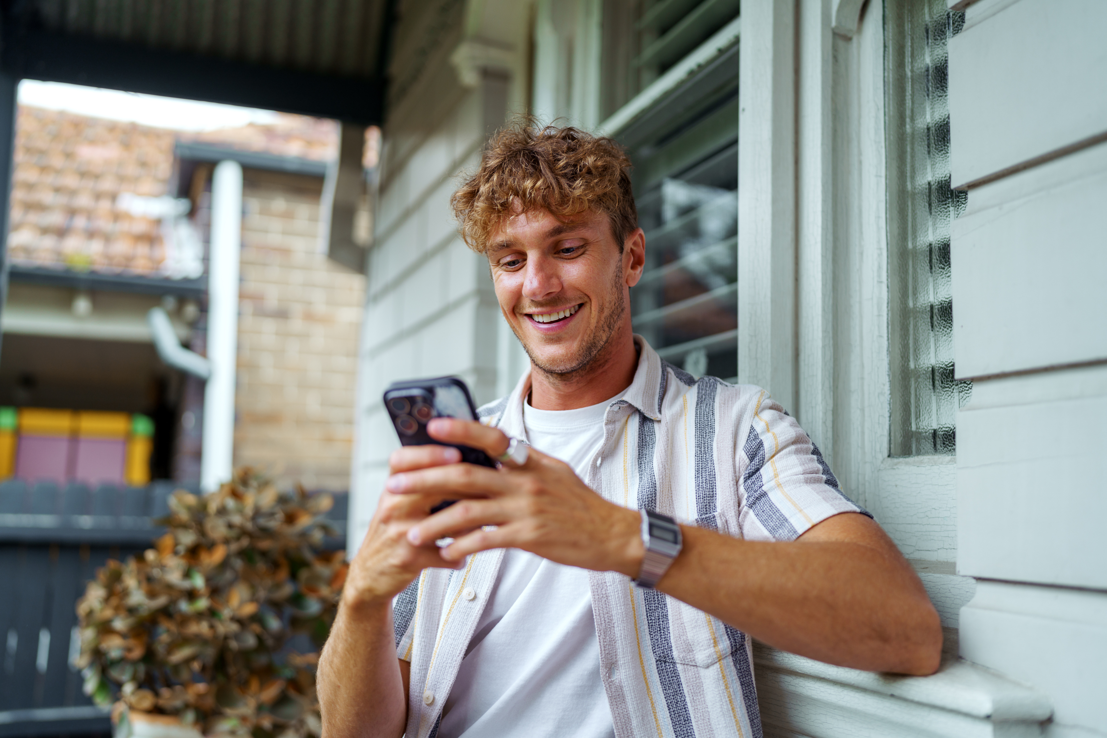 A man smiles at his phone.