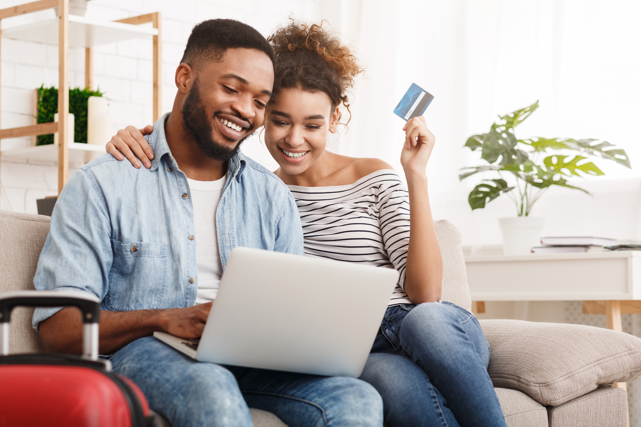 A man and a woman smiling at a laptop