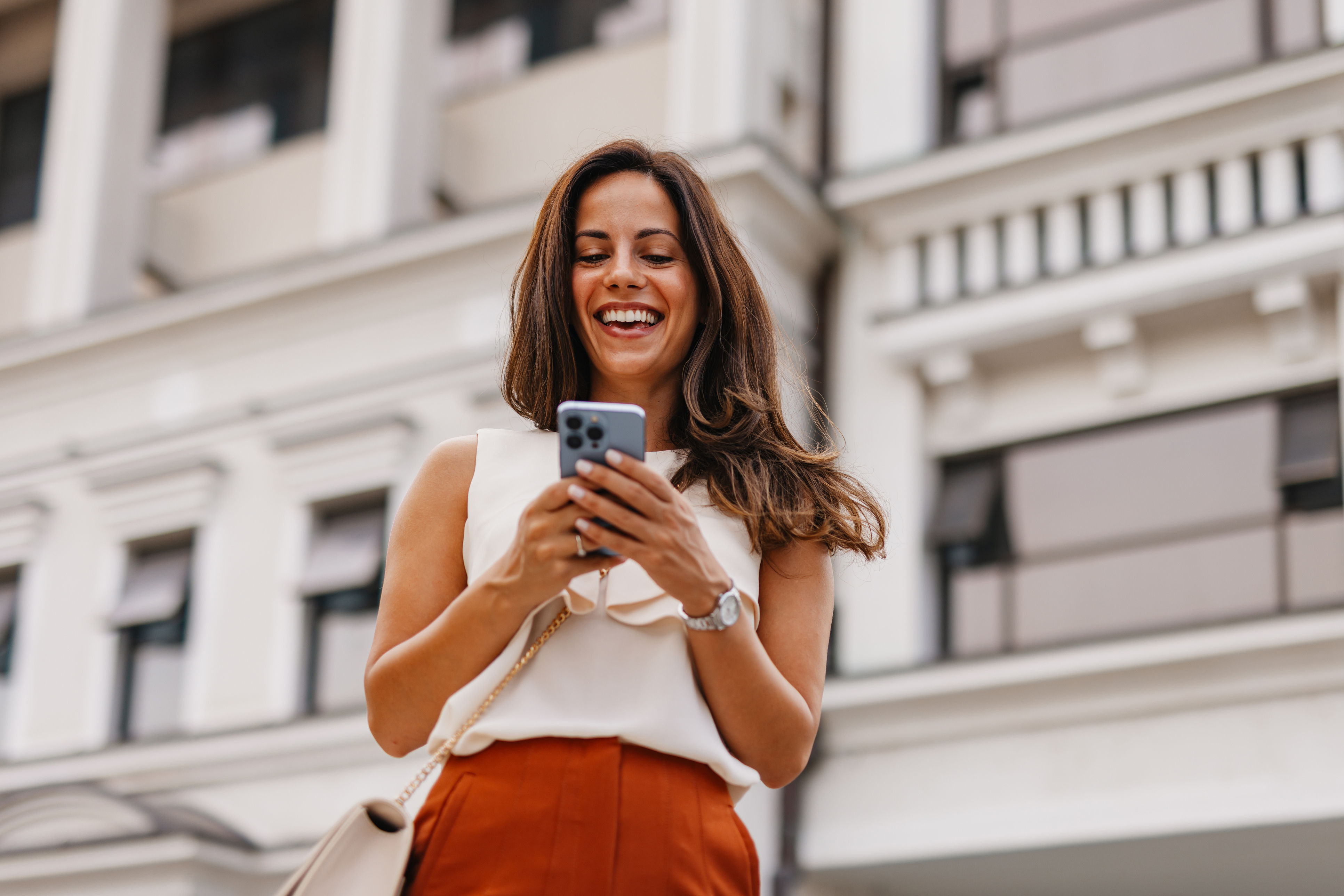 A woman smiles at a phone while comparing HELOC options.