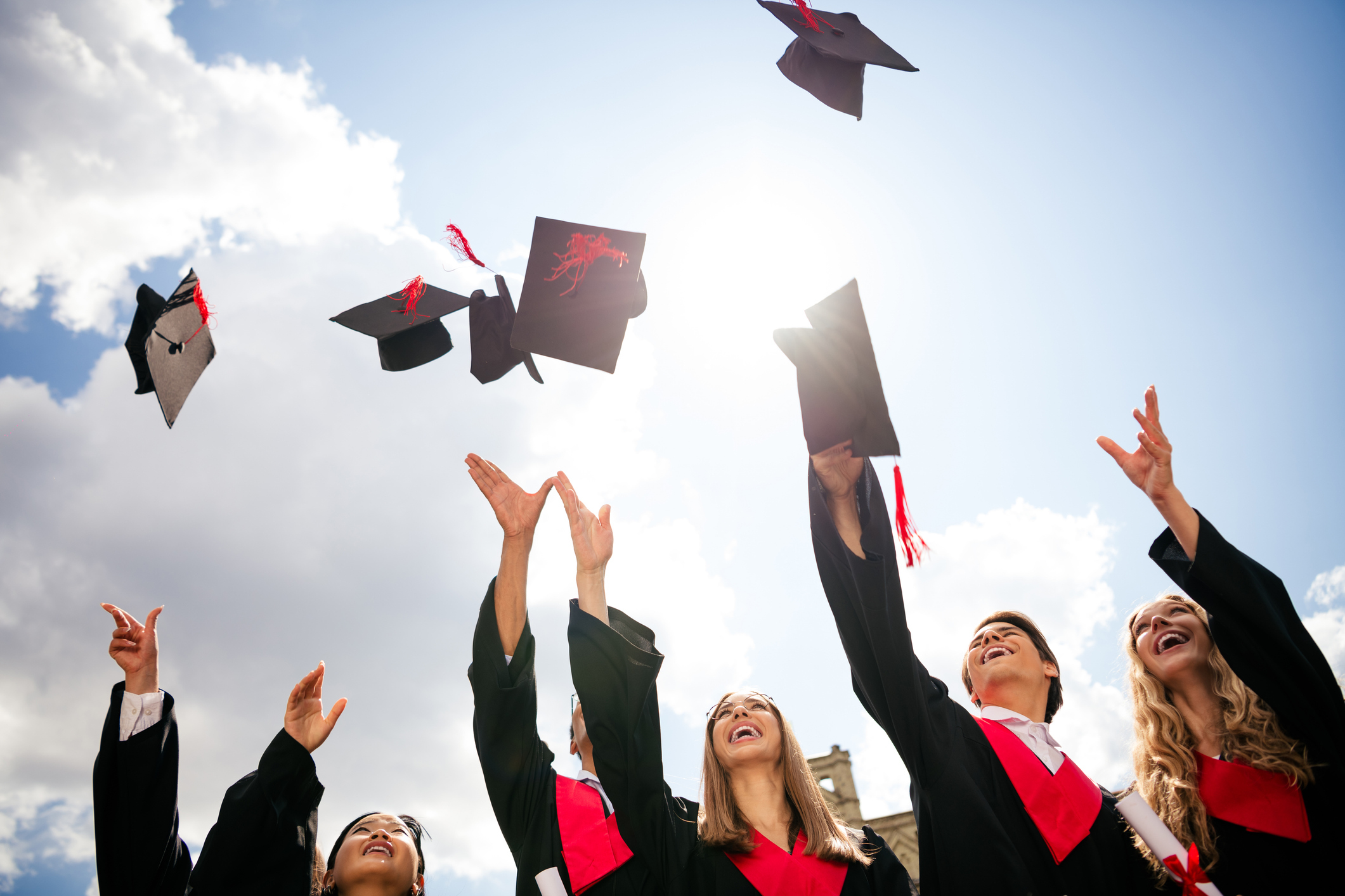 Graduates throw their caps in the air.