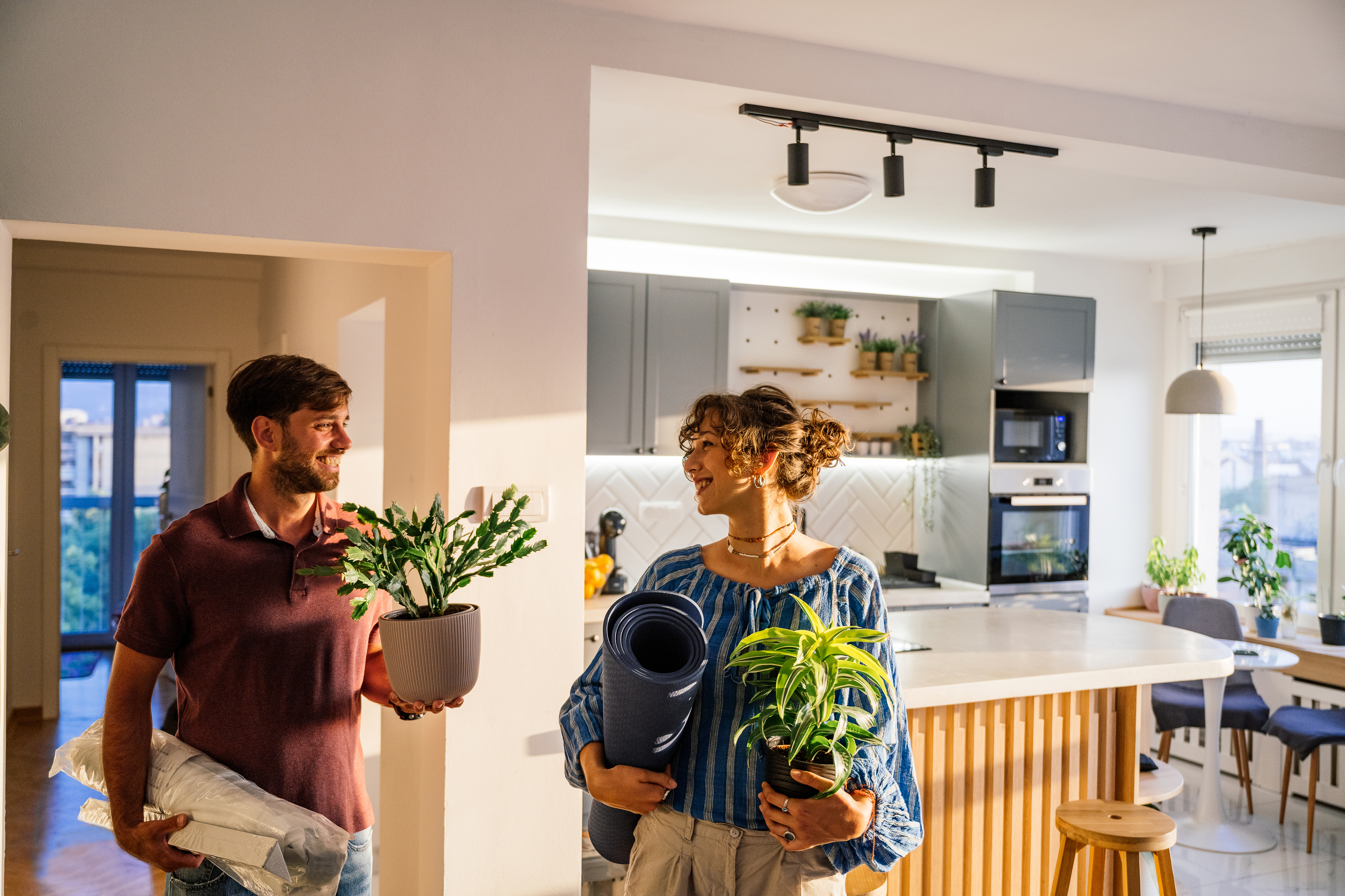 People smile while walking into a new home.