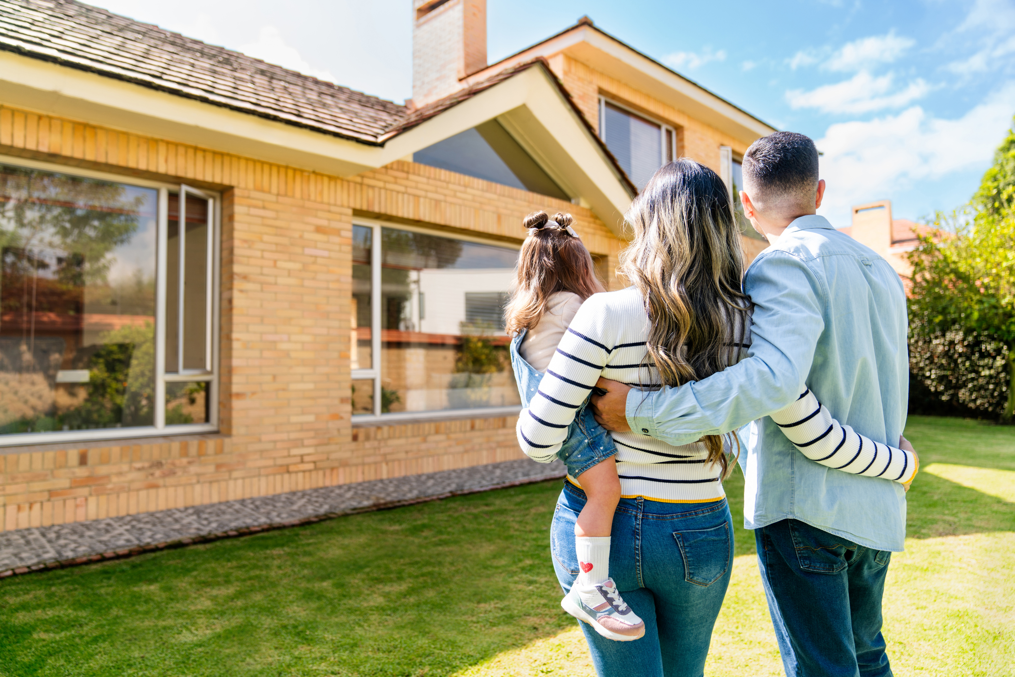 A man, woman, and child look at a newly purchased home.