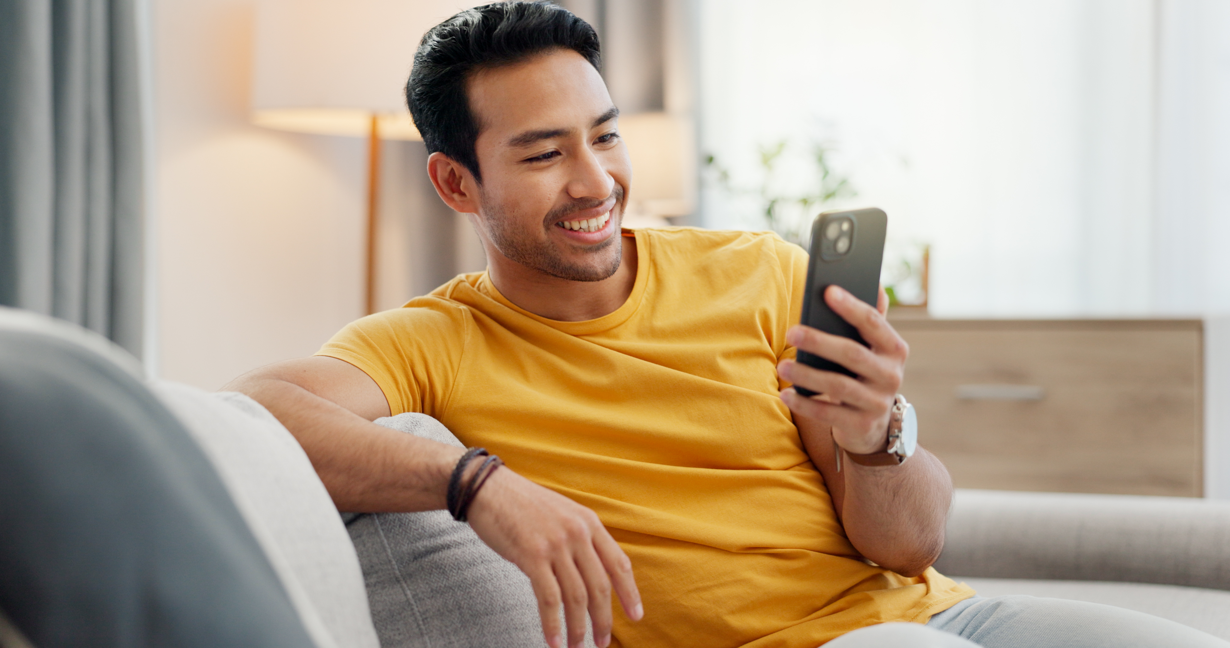 A man smiles at a phone.
