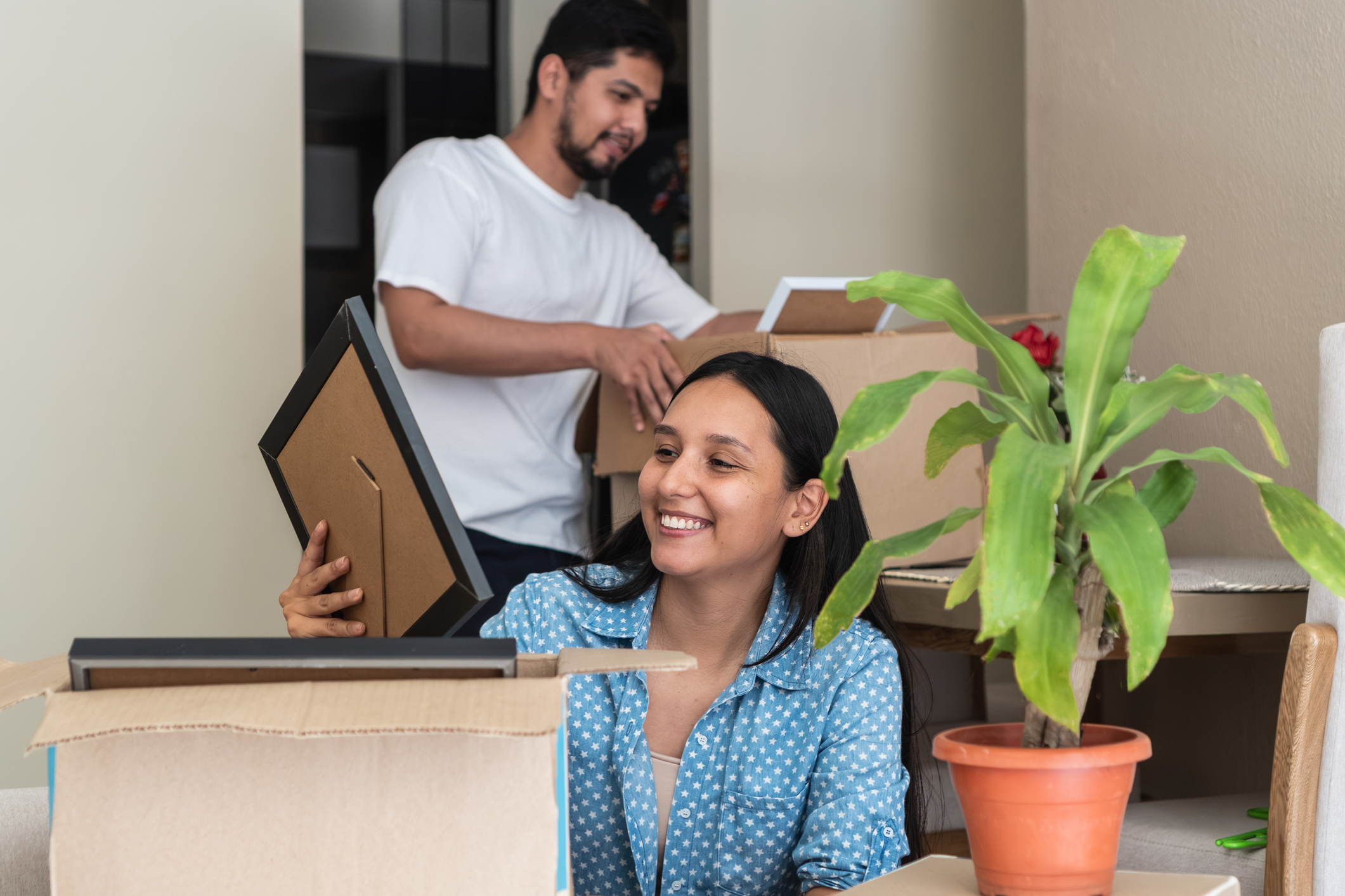 A man and a woman unpack boxes in a new home.