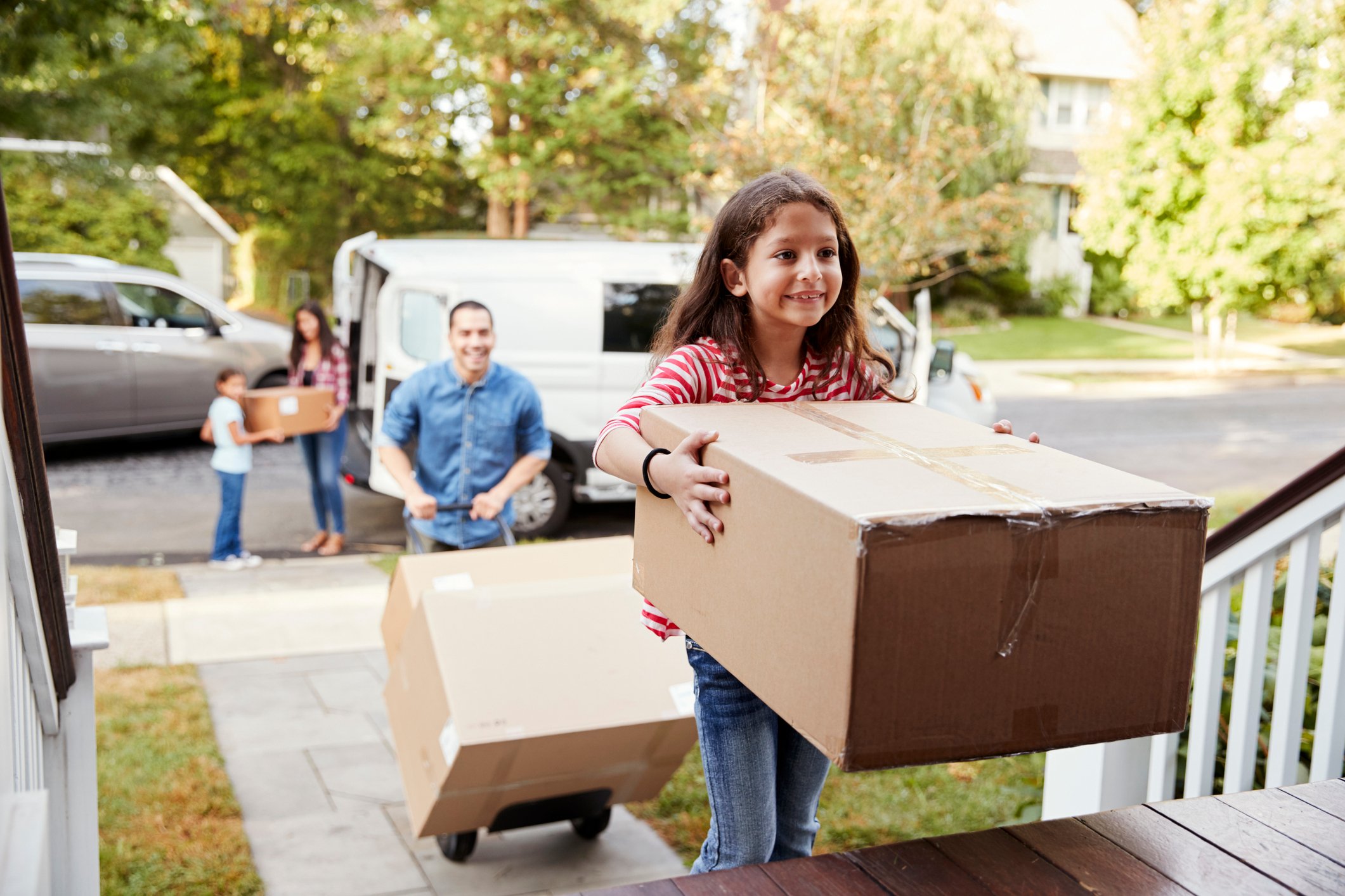 A man and a child move boxes into a home.