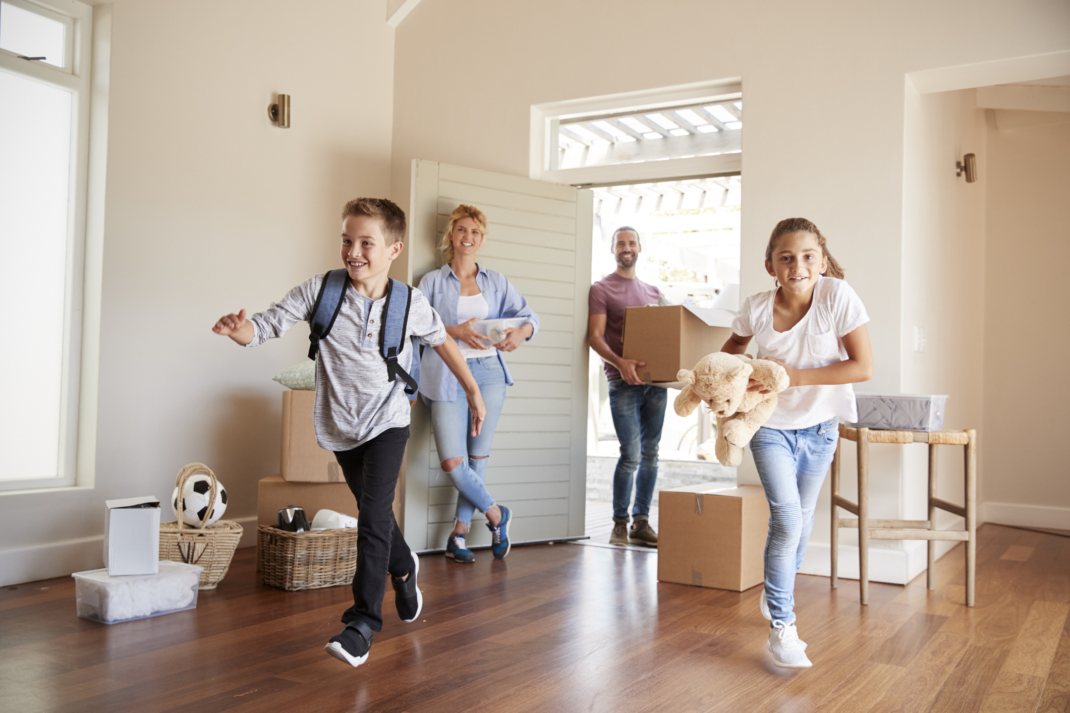 A family smiles while moving into a house.