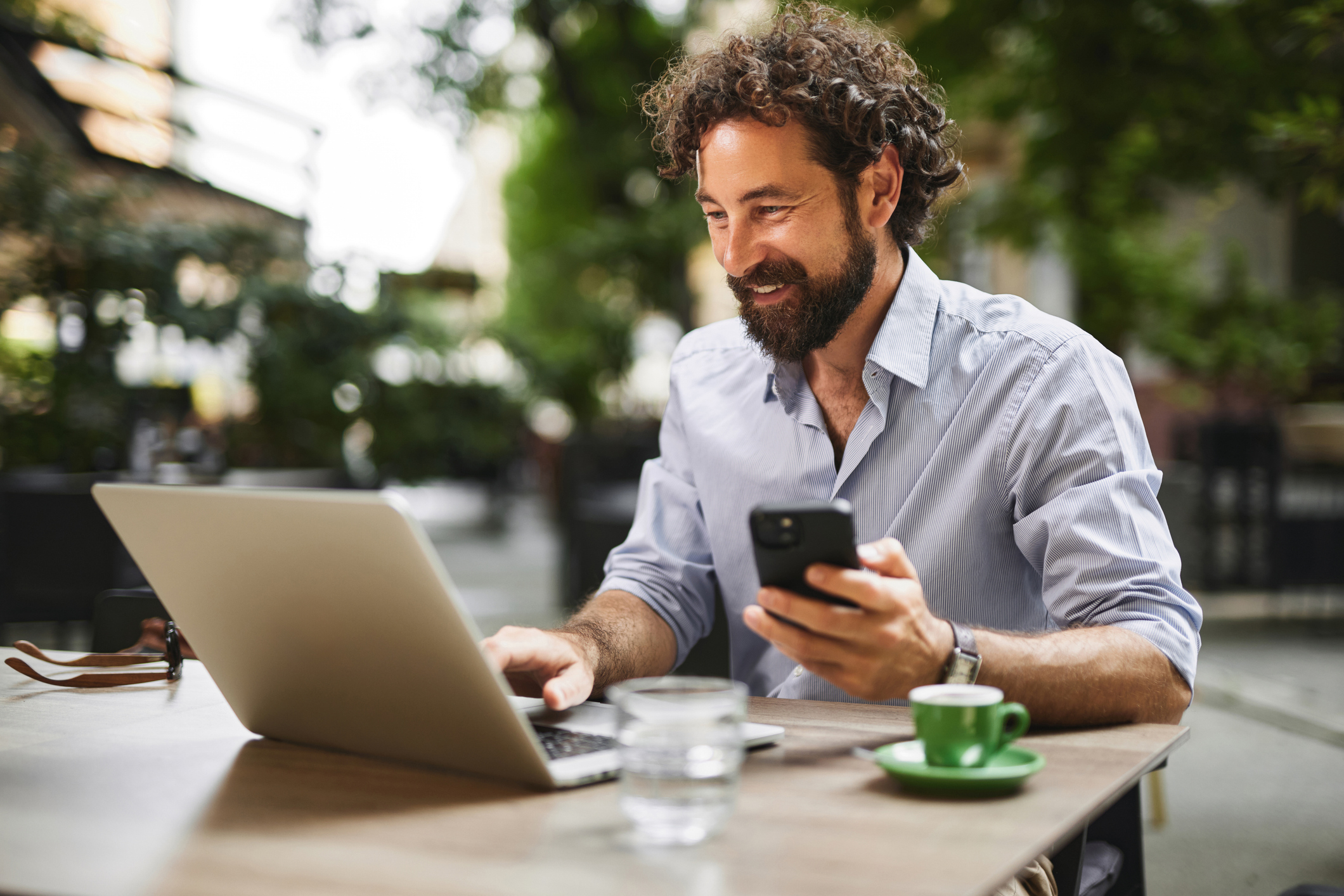 A man smiles at a laptop.